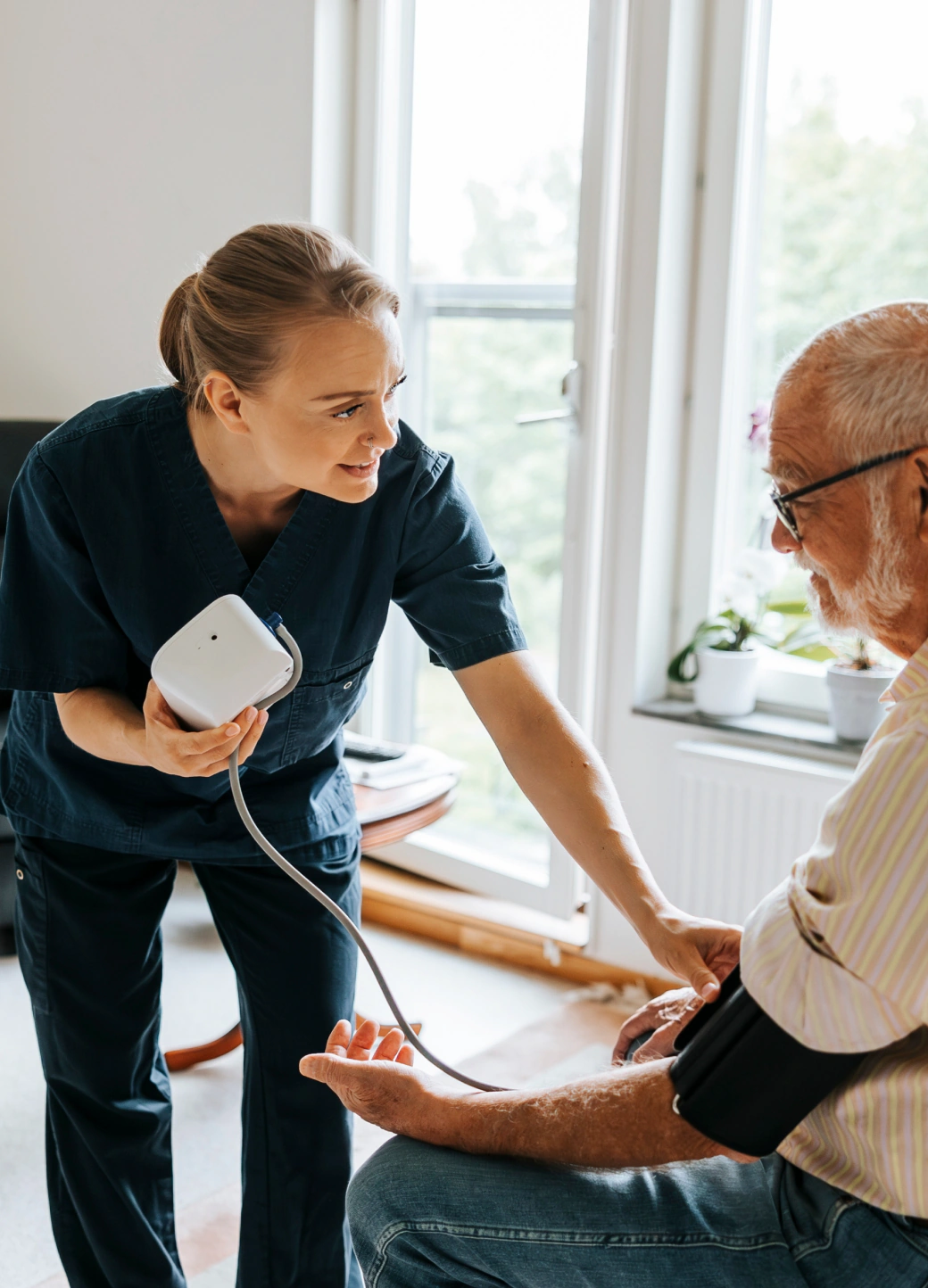 A clinician taking a patient's blood pressure at home