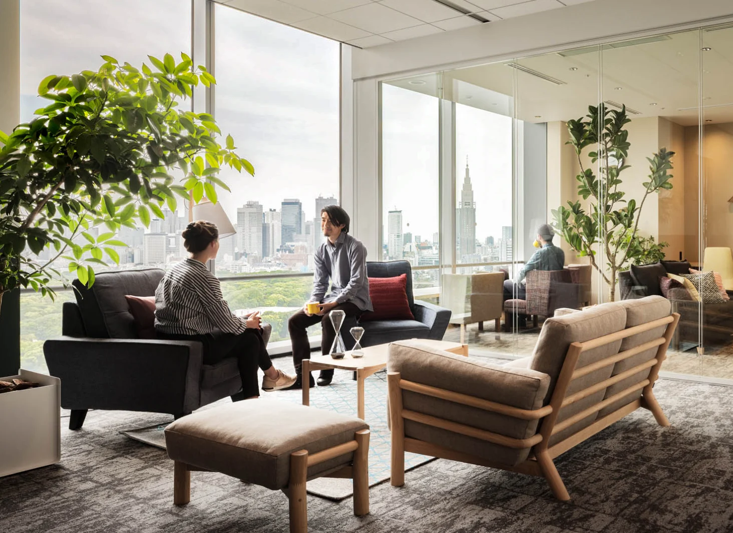 Colleagues talking in a sunlit office lounge